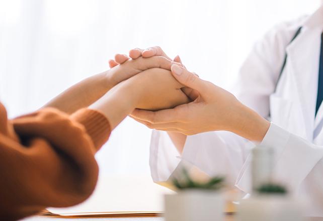 doctor and patient holding hands