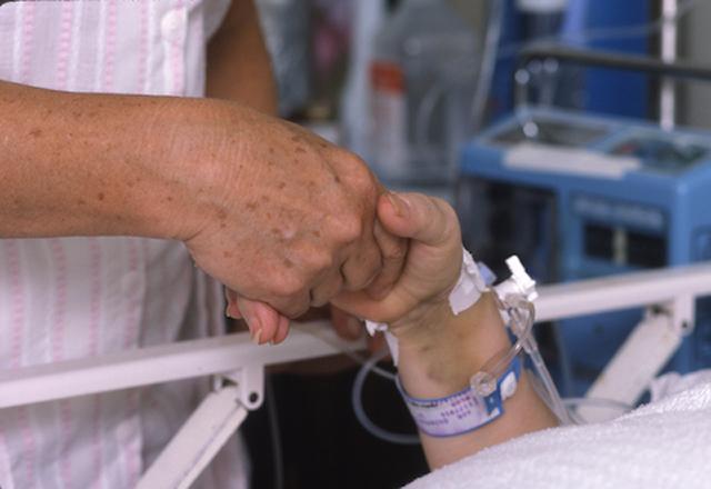 holding hands by hospital bed