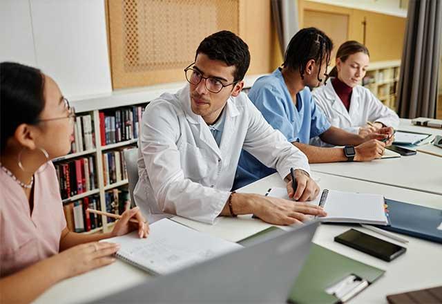 Medical professionals writing notes and talking among themselves.