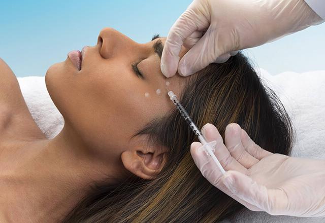 A woman receives an injectable neuromodulator treatment.