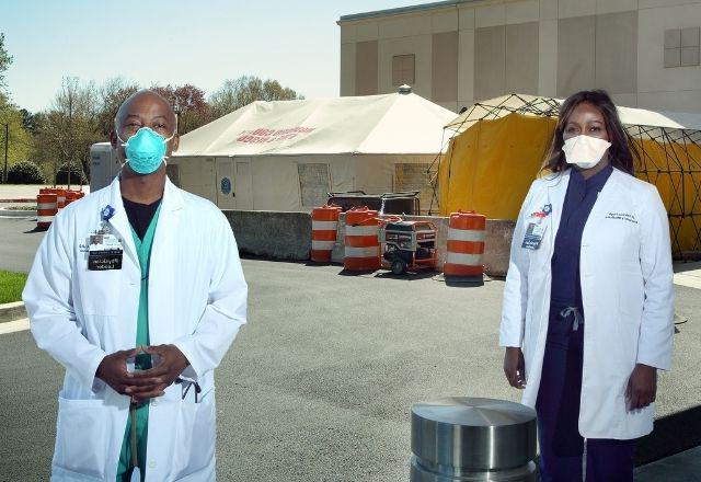 two physicians outside of a testing tent