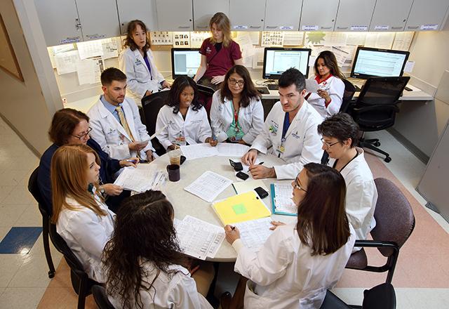 Faculty confer together around a table