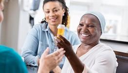 woman getting medicine from a nurse with her daughter