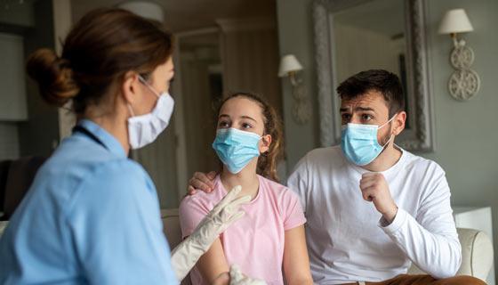 Father and teen talk to pediatric home health nurse