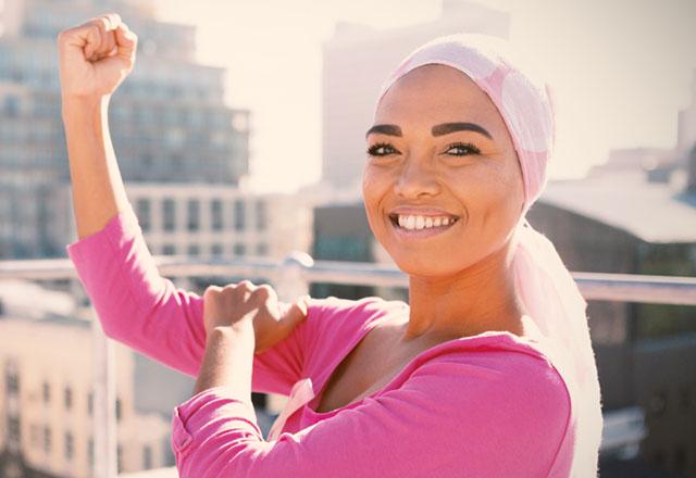 Woman in pink shirt holding up her fist.