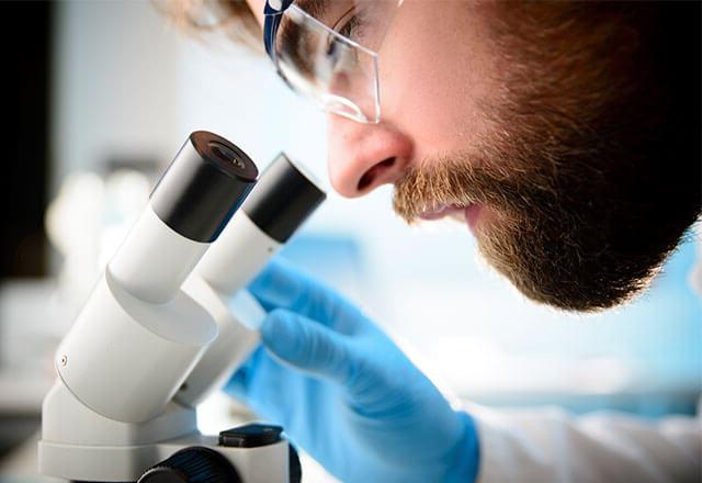 man using microscope