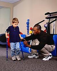 Picture of young boy, with canes, during a physical therapy session